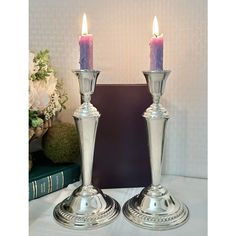 two silver candles sitting on top of a table