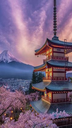 a tall tower sitting in the middle of a forest filled with pink flowers under a purple sky