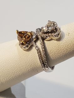 a close up of a ring on top of a white napkin with a bow design