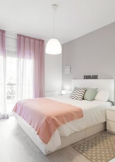 a bed room with a neatly made bed next to a window