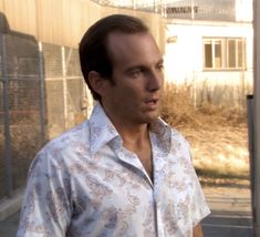 a man standing in front of a fence