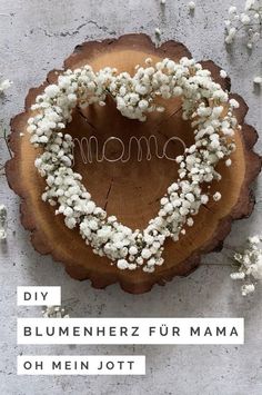 a heart shaped wreath with the word mom written on it and baby's breath