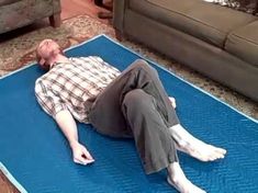 a man laying on a blue mat in the living room