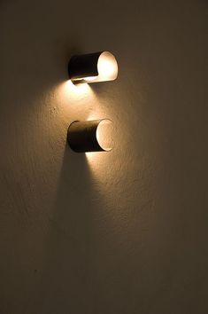 two lights are on the wall next to each other