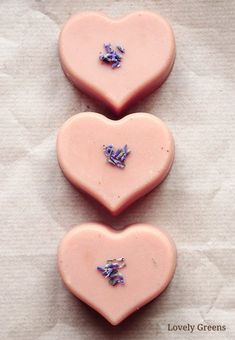 three pink heart shaped cookies sitting next to each other