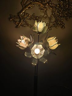 a light that is on top of a lamp post with flowers in the middle of it