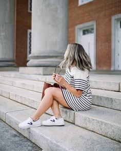 a woman sitting on steps looking at her cell phone