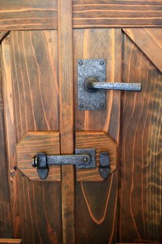 a close up of a wooden door with metal handles