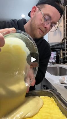 a man pouring batter on top of food in a pan