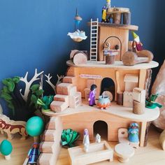 a wooden toy house with lots of toys around it