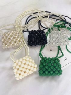 Detalles

 Presentamos nuestro mini bolso bandolera Beaded Pearl, un accesorio impresionante que combina sin esfuerzo elegancia con funcionalidad.

 Disponible en varios colores cautivadores, incluidos verde, crema, transparente, negro, blanquecino y rojo, este bolso seguramente complementará cualquier atuendo.

 Confeccionado en un estilo retro europeo y americano, este bolso irradia sofisticación y encanto atemporal.

 Su material acrílico y su diseño de bolso tejido añaden un toque de textura, mientras que las modernas cuentas embellecen el bolso con un toque de glamour.

 Diseñado para brindar comodidad, este mini bolso cruzado es perfecto para llevar sus elementos esenciales mientras viaja.

 Su forma de bola de masa y su tamaño compacto lo hacen ideal para el uso diario, mientras qu Hand Beaded Bag, Red Pearl, New Address, Pearl Bag, Beaded Bag, Beaded Handbag, Bag Ideas, Green Pearls, Green Beige