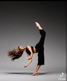 a woman is doing a handstand in the air with her legs spread out