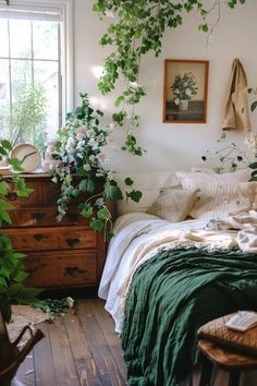 a bedroom with lots of greenery hanging from the ceiling and bed in front of a window