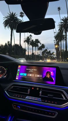 the dashboard of a car with an image of a woman on her phone and palm trees in the background