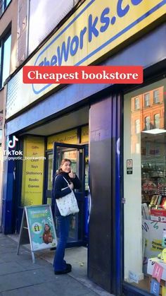 a woman standing in front of a book store with her hand on her hip and looking into the window