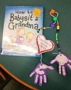 a book and handprints are on a table with a child's craft