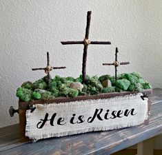 a wooden box with moss and crosses on it