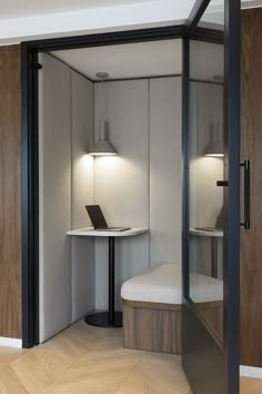 an open room with a laptop on a table and two lights above it in the corner