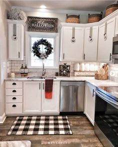 a kitchen with white cabinets and black and white checkered rug