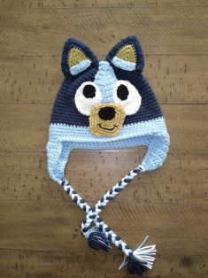 a crocheted blue and white hat with a dog face on it's side