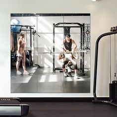 a man and woman doing squats in a crossfit gym with exercise equipment