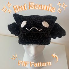 a crocheted black hat with white eyes and ears