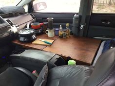 a table in the back of a truck with cups and other items on it's desk