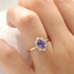 a woman's hand with a ring on it and a purple stone in the middle