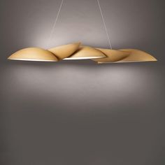 a modern light fixture hanging from the ceiling in a room with grey walls and flooring