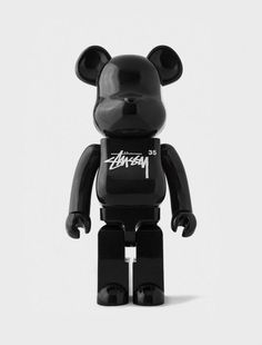 a black bear toy with white writing on it's face and ears, standing in front of a white background