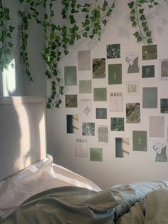 a bedroom with white walls and green plants on the wall