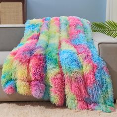 a multicolored throw blanket sitting on top of a couch