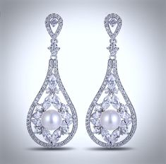 a pair of earrings with pearls and diamonds on the bottom, set in 18k white gold