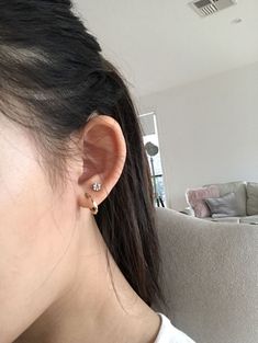 a close up of a person's ear with a couch in the back ground