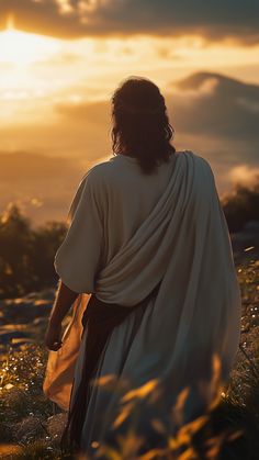 jesus walking through the field at sunset with his back turned to the camera, wearing a white robe