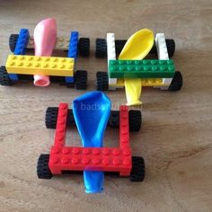 three toy cars made out of legos sitting on a wooden table next to each other