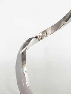 a metal sculpture on a white surface with a light in the middle and one arm extended