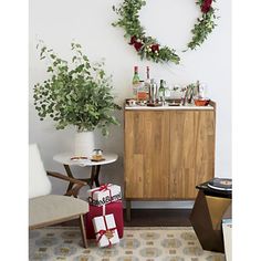 a living room filled with furniture and christmas decorations on top of a rug next to a wooden cabinet