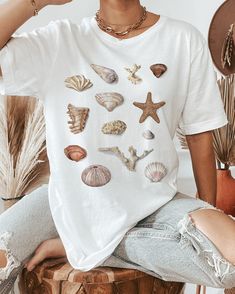 Our most summer-appropriate t-shirt featuring a watercolor sea shell art. Printed on a white t-shirt, made from durable lightweight cotton. Unisex fit - boxy and long. How it's made: * All prints are original watercolor designs hand-painted by a full-time artist. * Ethically made 100% cotton t-shirts that are made to last. * T-shirts are printed and shipped by my printing partner in the US, Canada, or Europe. * By buying from this shop you are directly supporting a woman-owned small business, created out of love for plants to educate, inspire and keep us connected to the natural world. About the artist: This Shop is an extension of my botanical illustration studio, where I create hand-painted watercolor art for international clients. Anna Farba Illustration is based in beautiful British Co White Beachy T-shirt For Beach Party, Casual White Shell For Beach Season, White Casual Shell For Beach Season, White Shell For Beach Season Vacation, Beachy White T-shirt For Beach Season, White Beachy T-shirt For Beach Season, White Beachy Shell For Beach Season, White Beachy Shell For Summer, White T-shirt For Beach Season