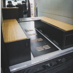 the back end of a van with wood flooring and metal parts on it's sides