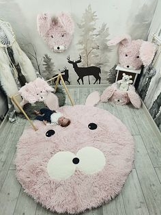 a baby is laying on a pink rug in the middle of a room with deer wallpaper