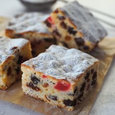 several pieces of cake sitting on top of a piece of paper with powdered sugar