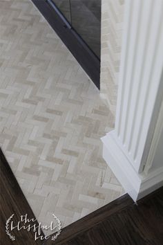 a bathroom with white and brown tile on the floor