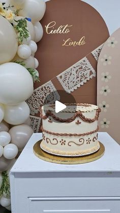 a white cake sitting on top of a table next to balloons and a heart shaped sign