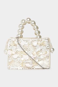 a white handbag with pearls on the handle