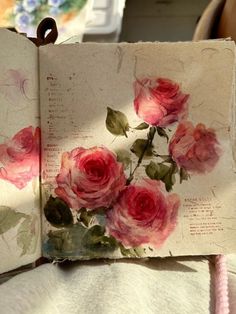 an open book with pink roses on it