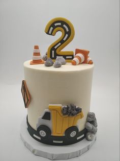 a birthday cake decorated with construction equipment and the number 2 on it's side