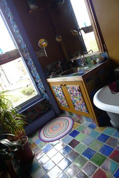 a bathroom with a sink, toilet and bathtub next to a potted plant