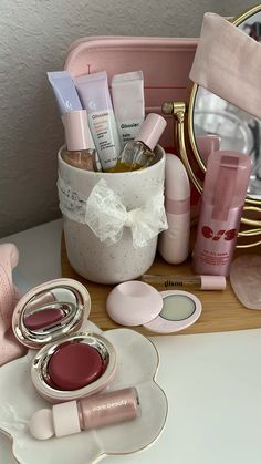 the contents of a pink cosmetic bag on a white table with a mirror in the background