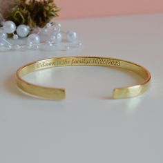 "Looking for the new daughter in law gift? Our \"Welcome to the family\" bracelet makes a great memento from Mother/Father in Law. - Laser engraving up to 90 characters on each side  - Coated with 22K gold and the thickness of the gold layer is 0.5 microns  - Text, coordinates, numbers or handwriting outside and inside the cuff  - Approximately 5mm wide, 1.2 mm thick - Laser engraved - the engraving is burned into the material using a laser beam.  SIZES: This is the length of the metal, not incl Engraved Name Bracelet For Anniversary And Mother's Day, Engraved Name Bracelet For Anniversary Mother's Day, Engraved Name Bracelet For Mother's Day Anniversary, Engraved Name Bracelet For Anniversary, Mother's Day Gift, Engraved Bangle Bracelet For Wedding, Adjustable Yellow Gold Wedding Bangle, Heirloom Style Adjustable Cuff Bracelet For Weddings, Classic Personalized Bracelets For Wedding, Yellow Gold Name Bracelet With Engraving Option